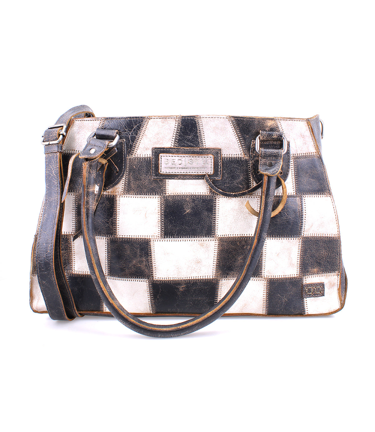 The Bed|Stü Rockababy SL is a rectangular, sustainable handbag featuring a black and white checkerboard pattern, two handles, and an adjustable shoulder strap.