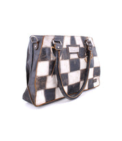 Introducing the Rockababy SL by Bed|Stü—a spacious, sustainable tote featuring a black and white checkerboard patchwork design, dual handles, and a signature rectangular front label. This eco-conscious handbag perfectly merges bold style with mindful fashion.