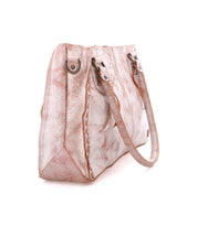 The Rockababy by Bed Stu is a textured beige handbag with brown accents, two handles, metal details, and a stitched design. It comes with a crossbody strap for added versatility.