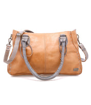 Introducing the Rockababy by Bed|Stü: a compact tan leather bag with gray handles and an adjustable crossbody strap, expertly crafted from vegetable-tanned leather. It features stitched detailing and a small metal Bed|Stü tag on the front.