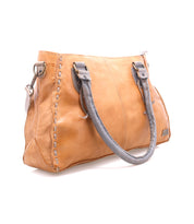 Rockababy by Bed|Stü is a compact, light brown vegetable-tanned leather handbag featuring gray handles and detailed stitching, shown against a white background. This stylish leather bag offers timeless appeal and functional elegance.