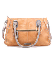 The Rockababy by Bed|Stü is a compact tan bag made from vegetable-tanned leather, featuring gray handles, a front zipper pocket, decorative stitching, and a metal Bed|Stü brand plate at the bottom center.