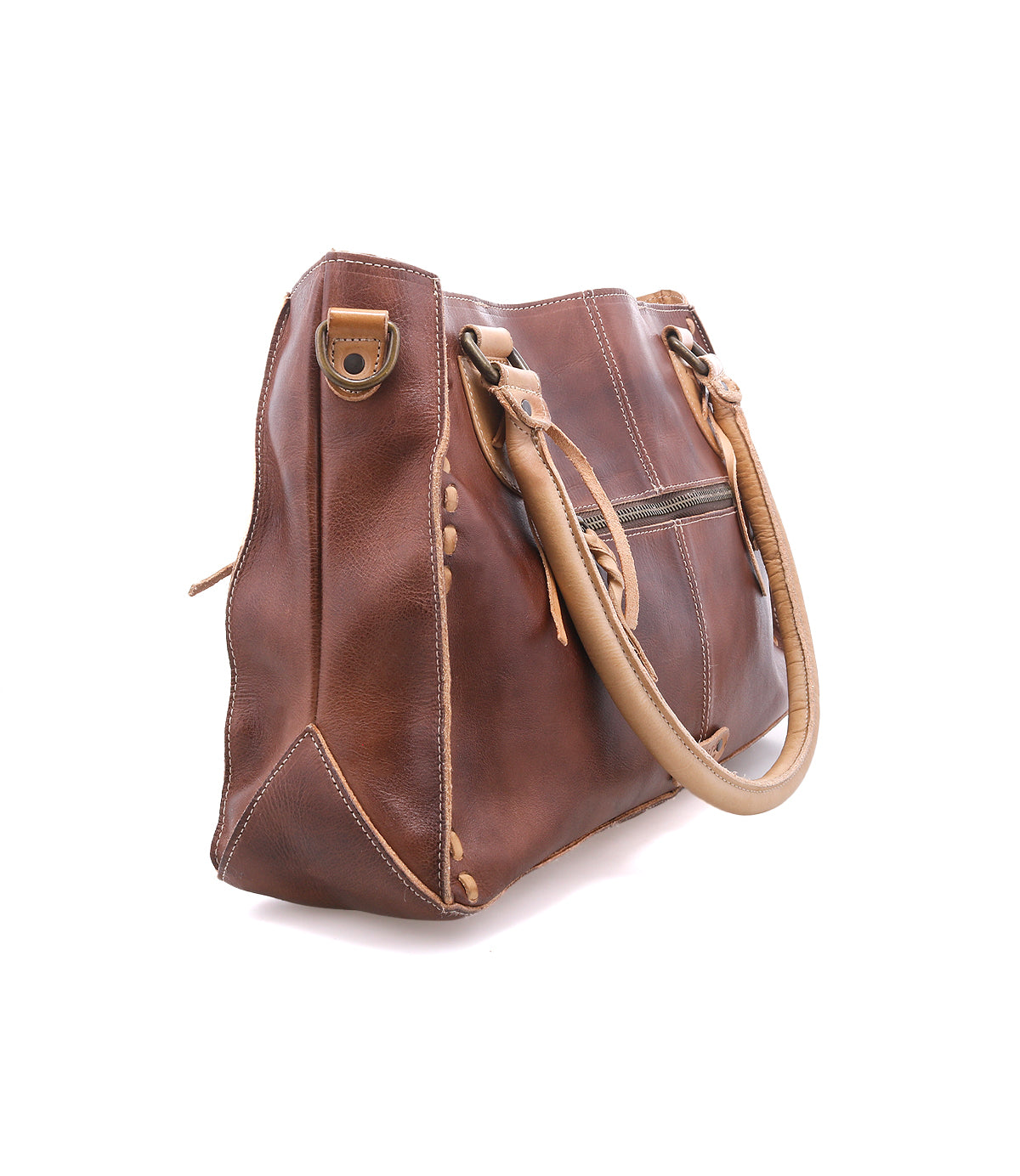 The Bed|Stü Rockababy is a brown, vegetable-tanned leather handbag featuring tan handles, visible stitching details, and a zipper pocket on the side, photographed on a white background. This compact leather bag also includes a convenient crossbody strap for versatile carrying options.