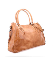 The Bed|Stü Rockaway is a light brown full-grain leather handbag featuring double handles, visible stitching, and a detachable shoulder strap, crafted for everyday function and displayed against a white background.