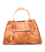 The Bed|Stü Rockaway is a large tan handbag made from full-grain leather, featuring two handles, a front zipper pocket, and visible edge stitching for everyday functionality, shown against a white background.