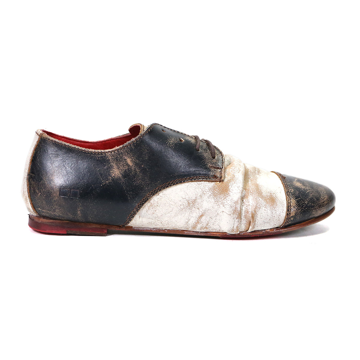 The Rumba II by Bed|Stü is a two-tone lace-up leather oxford featuring black and white scuffed leather, visible distress marks, red interior lining, and a worn finish—captured here in a left side view, this shoe artfully blends timeless design with stylish comfort.