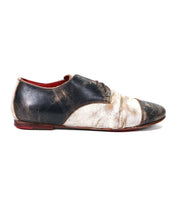 The Rumba II by Bed|Stü is a two-tone lace-up leather oxford featuring black and white scuffed leather, visible distress marks, red interior lining, and a worn finish—captured here in a left side view, this shoe artfully blends timeless design with stylish comfort.