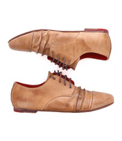 The Bed|Stü Rumba II is a pair of tan lace-up leather shoes featuring brown laces and striking red soles, shown from the side on a white background—perfect for adding stylish comfort to any occasion.