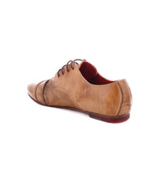 The Bed|Stü Rumba II showcases a brown leather lace-up design with a low heel, viewed from the rear side angle, highlighting subtle creases and a striking red interior lining—these shoes seamlessly combine stylish comfort with timeless sophistication.