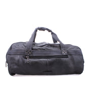 The Bed|Stü Ruslan is a black leather duffel bag featuring durable canvas straps, two top handles, a front zipper pocket, and a main zipper closure, photographed against a white background—perfect as an elegant travel bag.