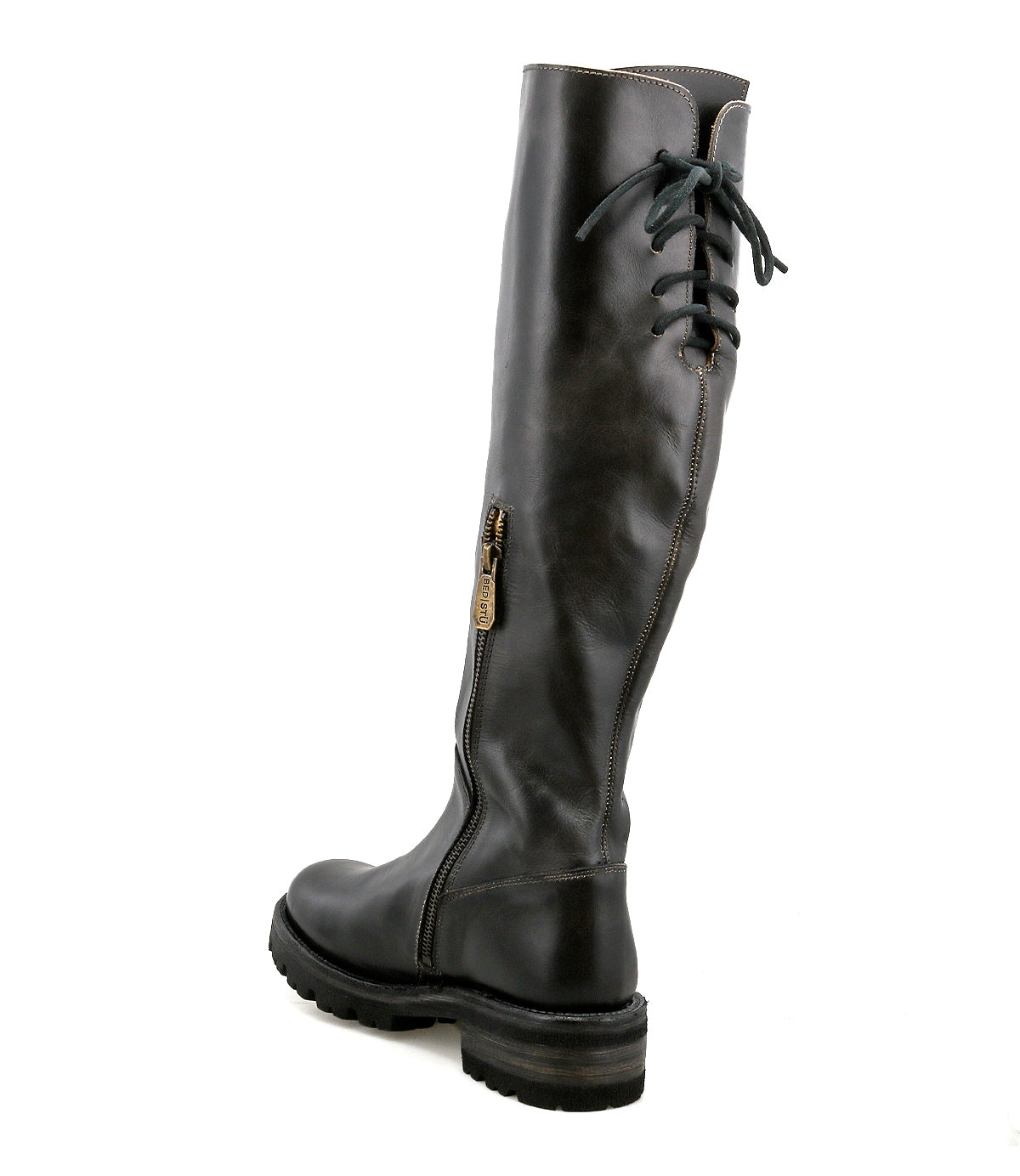 The Bed|Stü Scope boot is a black, knee-high leather style crafted from vegetable-tanned leather, featuring a side zipper, lace-up back detailing, and a thick treaded sole. Shown from a rear-side angle.