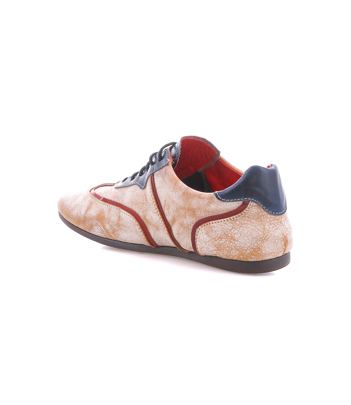 A beige Bed|Stü Scurry II sneaker with red and navy blue accents, black laces, and a flat brown sole is displayed from a rear side angle on a white background. This low-profile shoe features an easy lace-up design for everyday comfort.