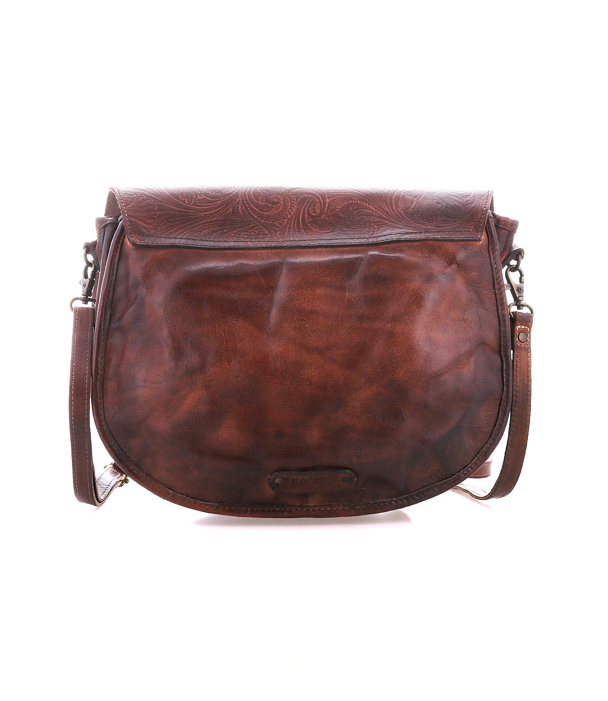 The Sequoia EM by Bed|Stü is a brown leather crossbody satchel bag, crafted from vegetable-tanned leather with a subtle embossed pattern on the flap. Featuring a curved saddle bag silhouette and an adjustable shoulder strap, this stylish accessory is displayed against a white background.
