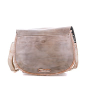Bed|Stü Sequoia is a light brown vegetable-tanned leather crossbody messenger bag with a flap closure and adjustable strap, featuring a small metallic logo plate at the bottom center of the flap.