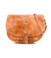 The Bed|Stü Sequoia is a brown vegetable-tanned leather crossbody satchel featuring a front flap, buckle strap closure, and an adjustable shoulder strap, displayed against a white background.