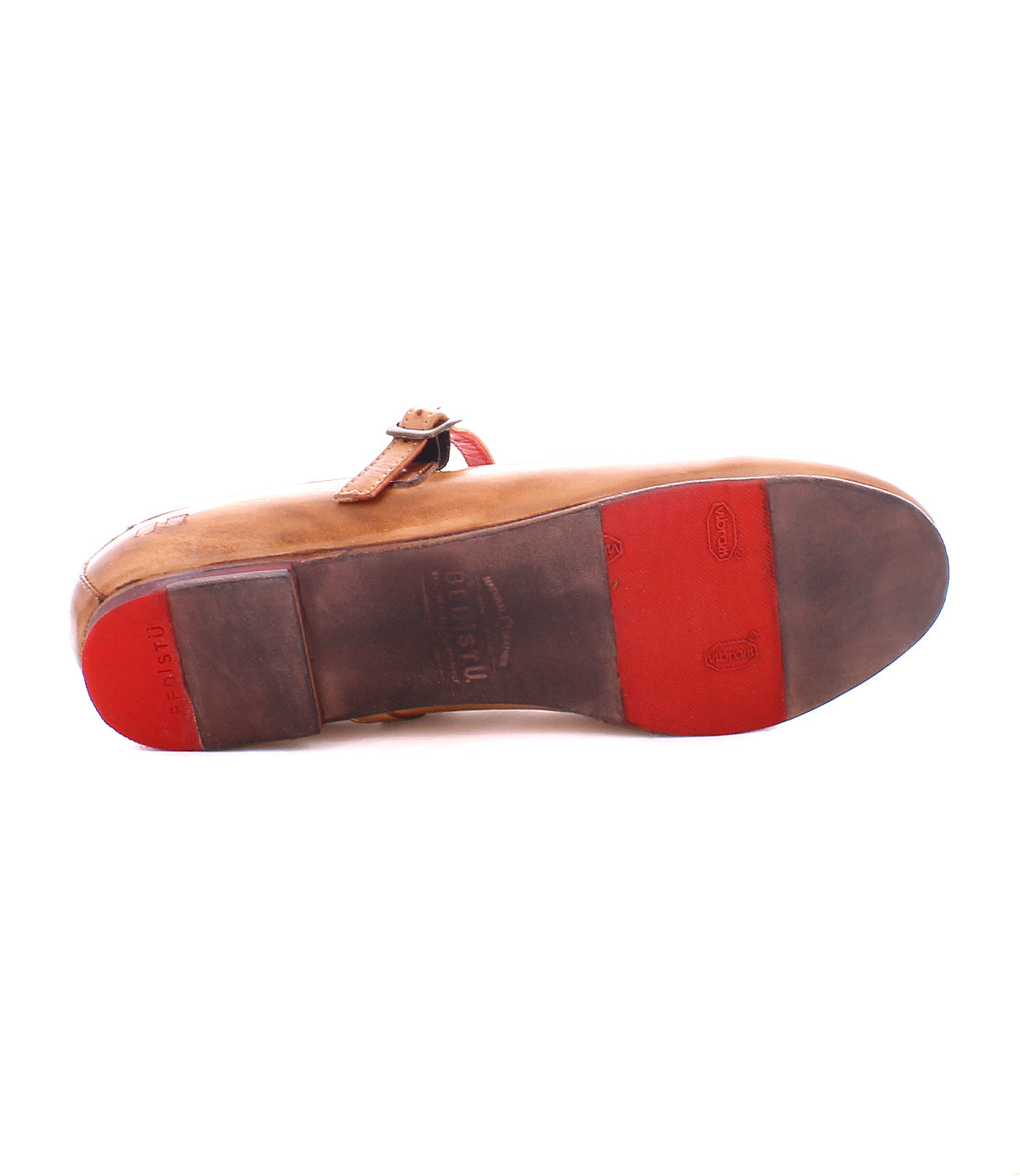 The Bed|Stü Shuffle III is a supple brown leather ballet flat, showcased from the sole side with distinctive red rubber accents at the toe and heel, plus a side buckle strap. This feminine shoe combines comfort with unique style.