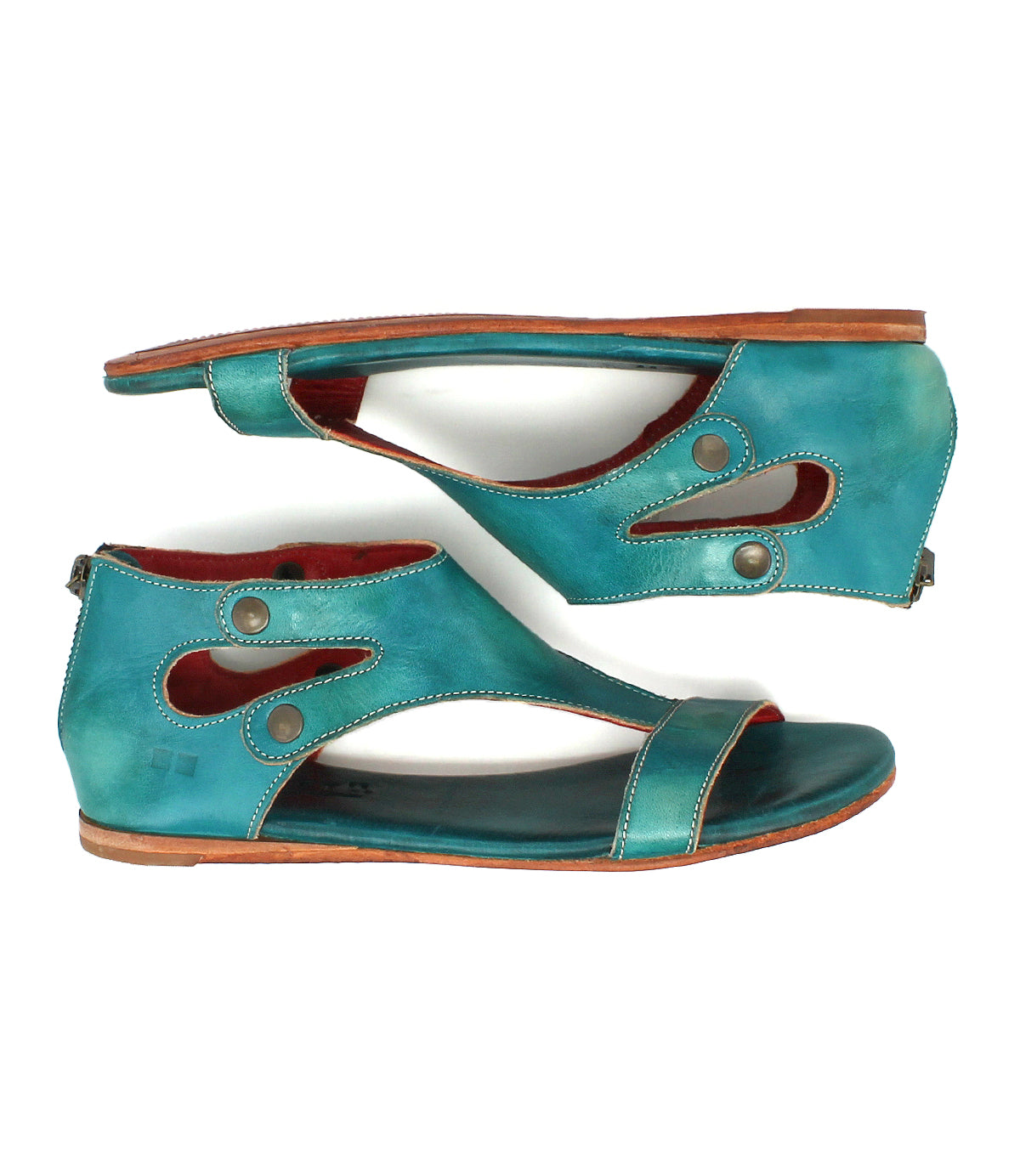 The Bed|Stü Soto sandals—a pair of flat, turquoise cutout leather sandals with metal button accents and a convenient heel zipper—feature a cushioned footbed for all-day comfort, making them ideal for everyday exploring. Shown side by side against a white background.