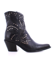 The Sposa ankle boot by Bed|Stü is an Italian-crafted bootie made from vegetable-tanned black leather, featuring a mid-height block heel, a pointed toe silhouette, and adorned with silver studs arranged in an elegant swirling pattern.