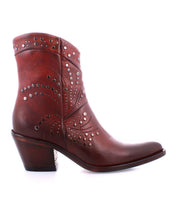 The Sposa ankle boot by Bed|Stü is crafted from vegetable-tanned brown leather, adorned with decorative studs and stitched patterns, and set on a chunky heel, shown in a side profile against a white background.