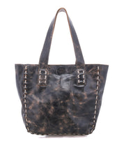Introducing the Stevie by Bed|Stü—a vintage-inspired black leather tote featuring prominent white stitching along the edges and two robust handles. Perfect for everyday use, this distressed bag is shown photographed on a white background.