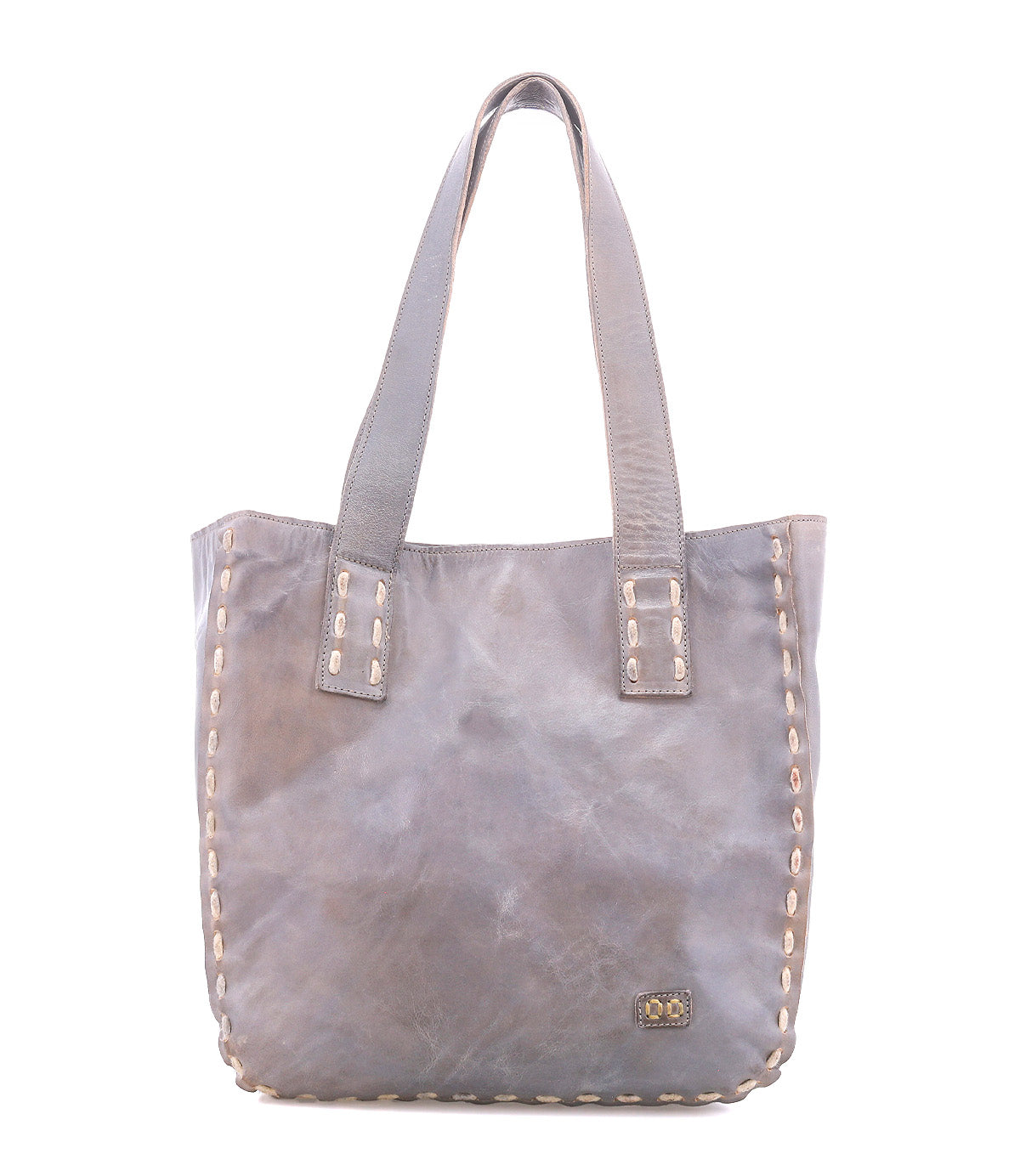 Introducing Stevie by Bed|Stü—a gray leather tote bag featuring double handles and decorative stitching along its edges. A small metal Bed|Stü logo plate accents the lower right corner. This classic tote seamlessly blends timeless style with everyday practicality, making it the perfect carryall for daily use.