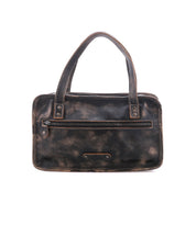 The Bed|Stü Stuffy is a black, rectangular leather handbag with two handles and a front zippered pocket, offering a spacious interior and showcased against a white background.