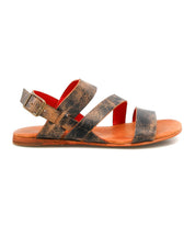 The Bed|Stü Superb is a brown leather sandal with three straps and a buckle, featuring a flat sole with a slight heel. Shown in side profile on a white background, this sandal is designed for everyday wear and includes an adjustable ankle strap for a secure and comfortable fit.