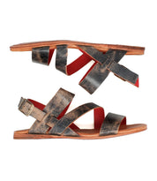 Superb by Bed|Stü: Flat leather sandals featuring distressed black leather straps, an adjustable ankle strap with a buckle on one side, red interior lining, and brown soles—shown in a side view and designed for everyday comfort.