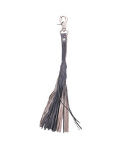The Bed|Stü Tassel Clip, crafted from black and brown leather with a silver clasp, is displayed against a white background—this stylish accessory serves as both a chic keychain charm and a versatile bag adornment.