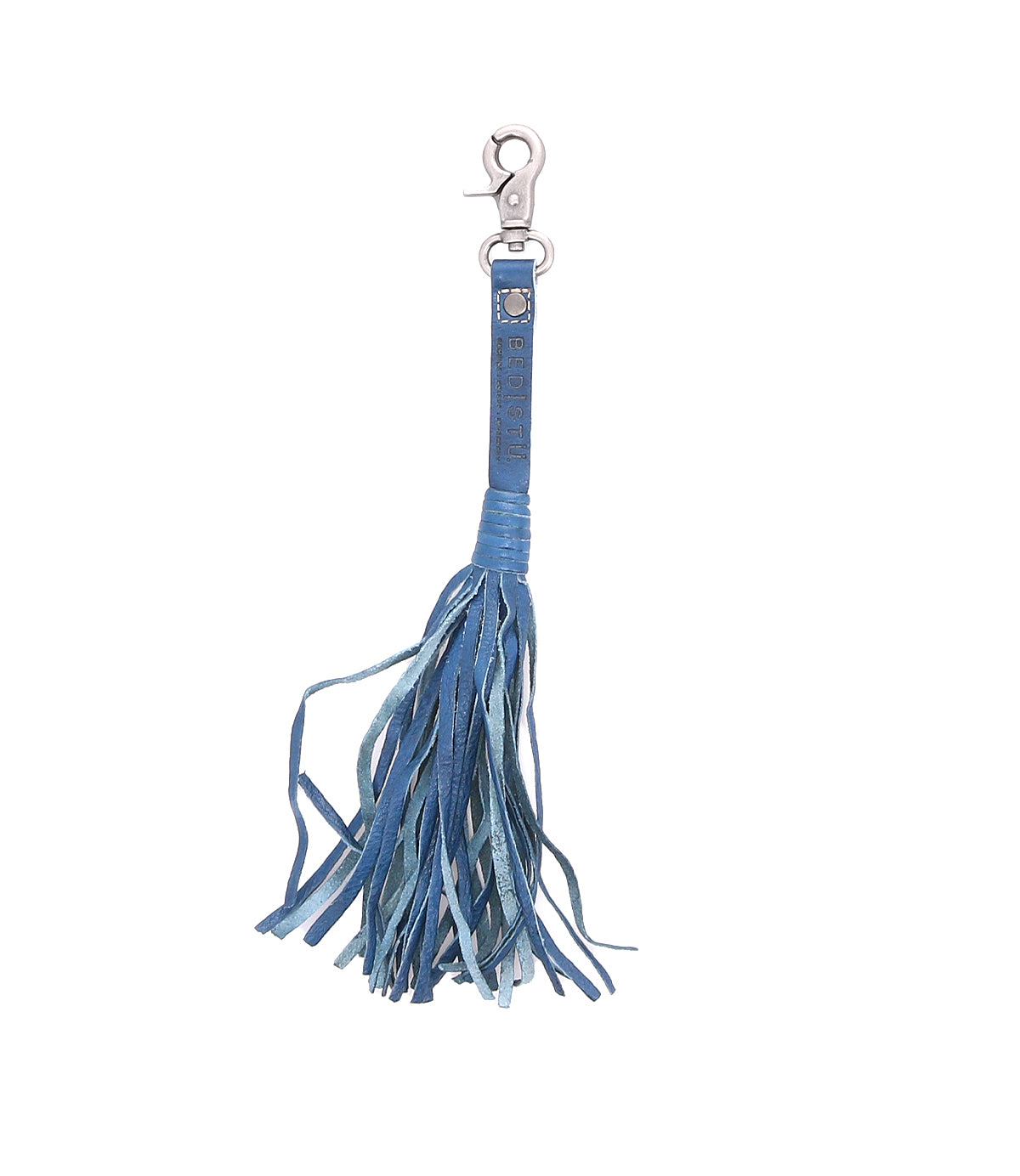 The Bed|Stü Tassel Clip is a blue leather keychain featuring multiple thin strips and a silver clasp, serving as both a stylish keychain charm and a chic bag accessory.
