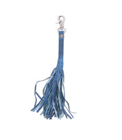 The Bed|Stü Tassel Clip is a blue leather keychain featuring multiple thin strips and a silver clasp, serving as both a stylish keychain charm and a chic bag accessory.