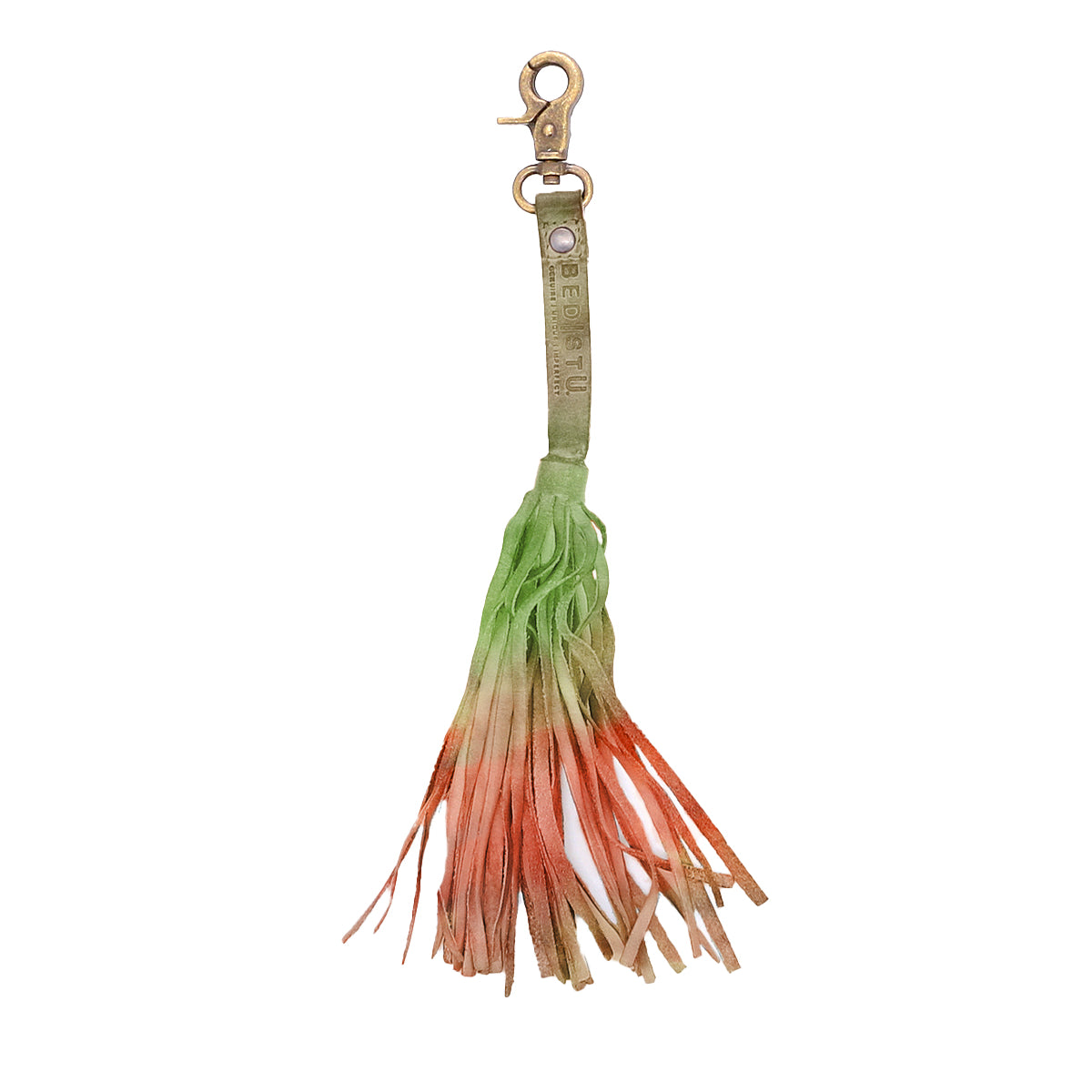 The Bed|Stü Tassel Clip features a leather keychain charm with a brass clasp and a fringed tassel in green, orange, and tan—perfect as a stylish bag accessory or leather tassel clip.