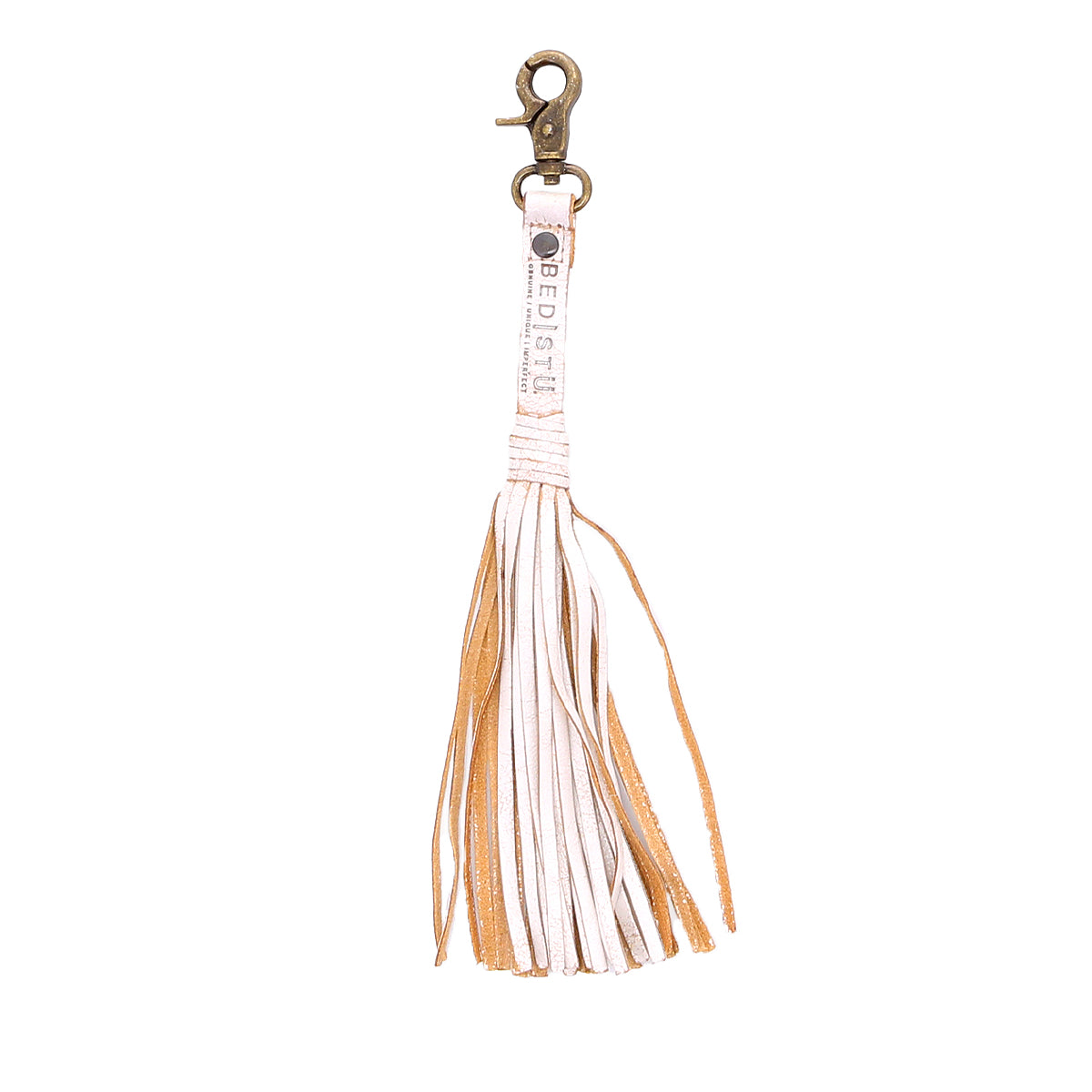 The Bed|Stü Tassel Clip is a tan and white leather keychain with a metal clasp, shown against a white background, making it a stylish bag accessory or charm.
