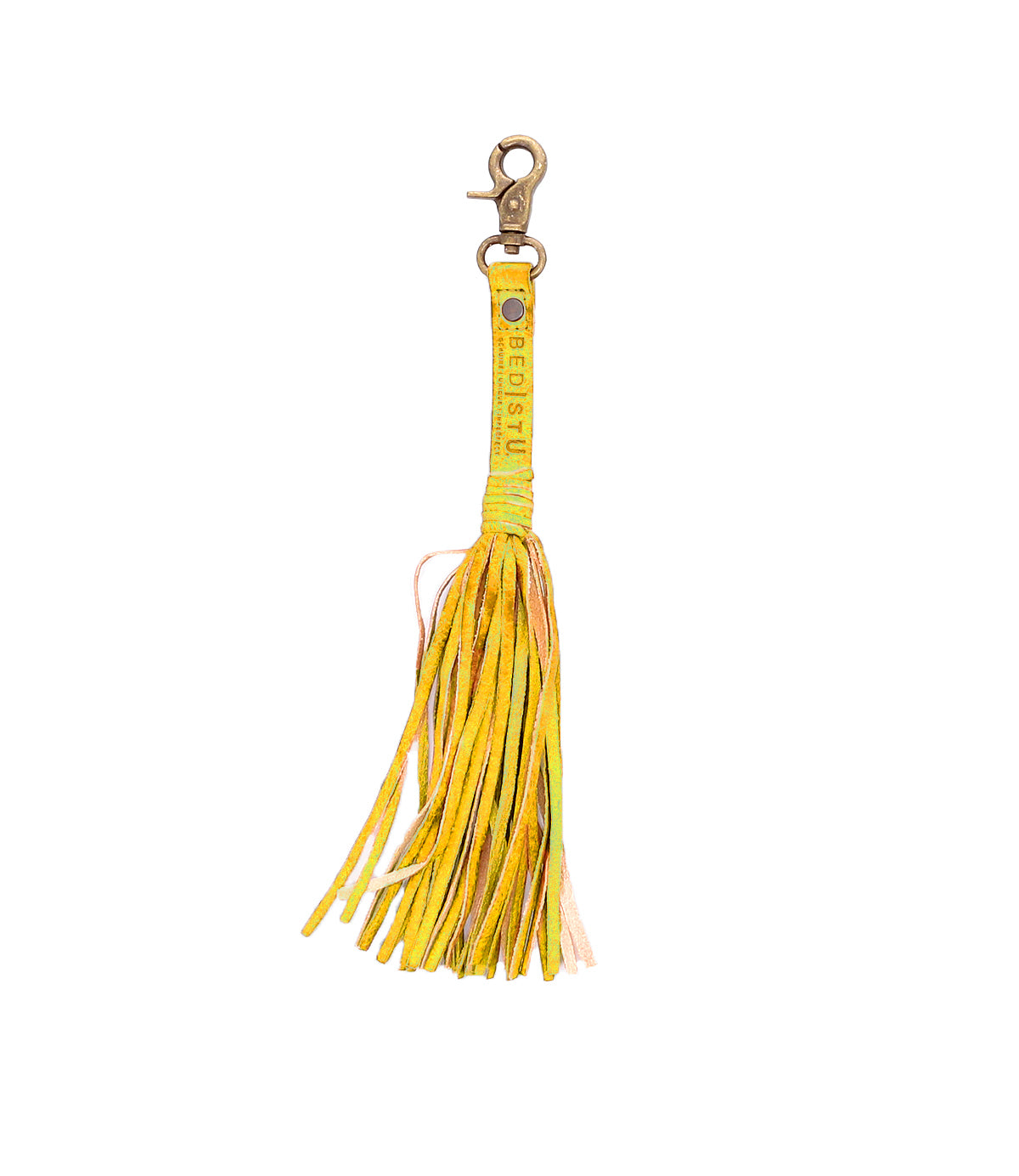 The Bed|Stü Tassel Clip is a yellow leather keychain featuring multiple fringed tassels, a gold clasp, decorative studs, and a text-embossed strip—making it a stylish bag accessory that doubles as the perfect leather charm for your everyday essentials.