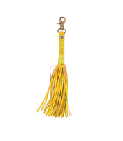 The Bed|Stü Tassel Clip is a yellow leather keychain featuring multiple fringed tassels, a gold clasp, decorative studs, and a text-embossed strip—making it a stylish bag accessory that doubles as the perfect leather charm for your everyday essentials.