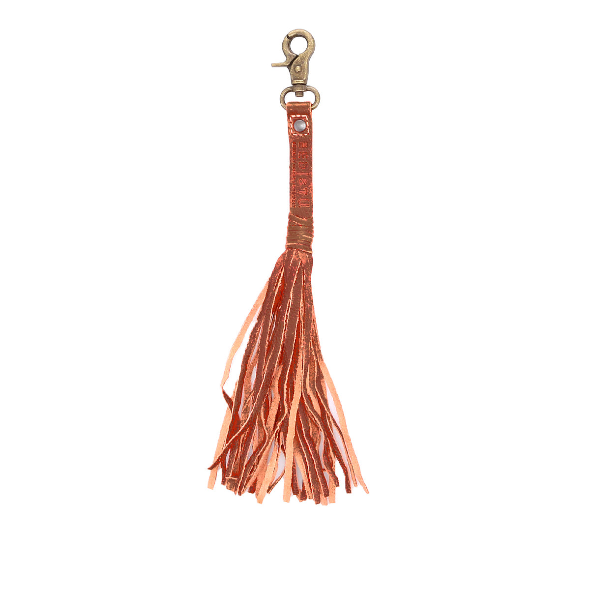 The Bed|Stü Tassel Clip is a rust-colored leather keychain featuring multiple fringed strands hanging from a looped strap and finished with a brass clasp—perfect for adding a stylish accent to your keys or bag.