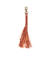 The Bed|Stü Tassel Clip is a rust-colored leather keychain featuring multiple fringed strands hanging from a looped strap and finished with a brass clasp—perfect for adding a stylish accent to your keys or bag.
