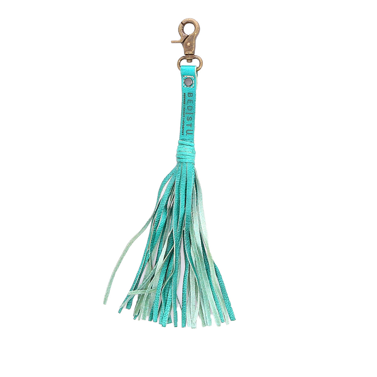 The Bed|Stü Tassel Clip features a teal leather design with multiple fringe strands and a gold clasp, making it a stylish accessory for your bag or a charming keychain. Shown against a white background.
