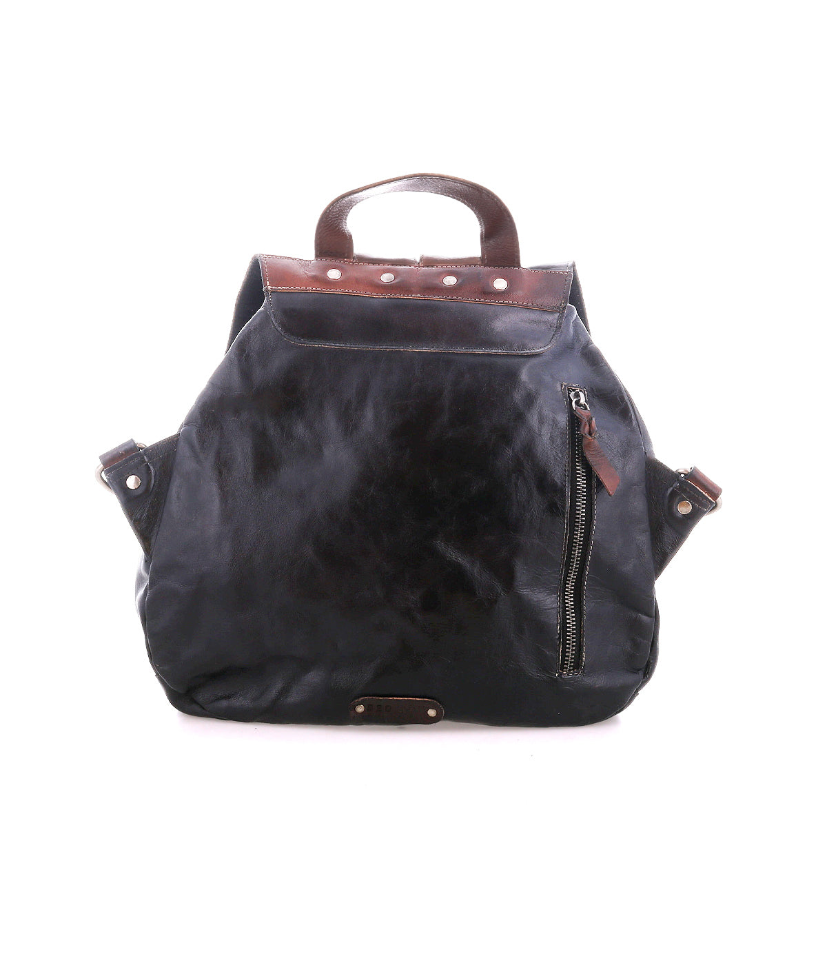 The Teji by Bed|Stü is a black leather backpack featuring brown leather accents, a top handle, zippered front pocket, and visible metal rivets. Blending classic design with the relaxed silhouette of a slouchy shoulder bag, it's displayed on a white background.