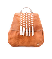 Introducing the Bed|Stü Teji—a light brown leather backpack featuring a flap closure, vertical silver chevron accents on the front, and a small rectangular patch at the bottom right corner. Drawing inspiration from classic handwoven leather bag styles, this piece beautifully combines artisanal charm with modern detailing.