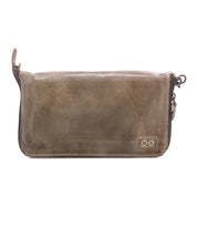 Templeton II by Bed|Stü—a brown leather zippered pouch featuring a small stitched logo patch in the bottom right corner—designed to function perfectly as a clutch or wallet, photographed on a white background.