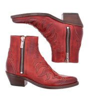 A pair of Tentativa red leather ankle boots by Bed|Stü, featuring side zippers, decorative stitching, and a low stacked wooden heel inspired by vintage Western style, displayed side by side against a white background.