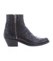 The Tentativa boot by Bed|Stü is a handcrafted Italian black leather ankle boot featuring a side zipper, decorative upper stitching, and a low angled stacked heel; shown in profile on a white background, it exudes sophisticated style with subtle vintage Western influences.