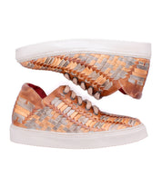 Two comfortable Bed|Stü Unwavering sneakers with woven metallic gold and silver uppers, white soles, and brown laces are displayed side by side against a white background.