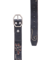 Bed|Stü's Upswing II is a black leather belt with a silver buckle, featuring a floral cutout design, stitched edges, and metal rivet accents—an artisanal accessory perfect for elevating any look.