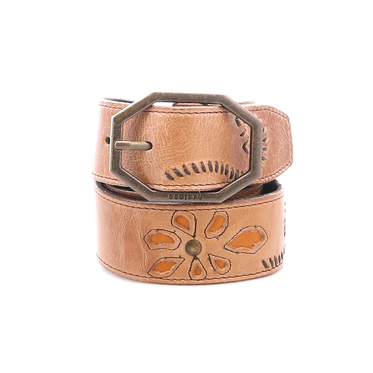 The Upswing II by Bed|Stü is a tan handcrafted leather belt featuring an engraved floral pattern and an octagonal brass buckle, shown rolled up against a white background.