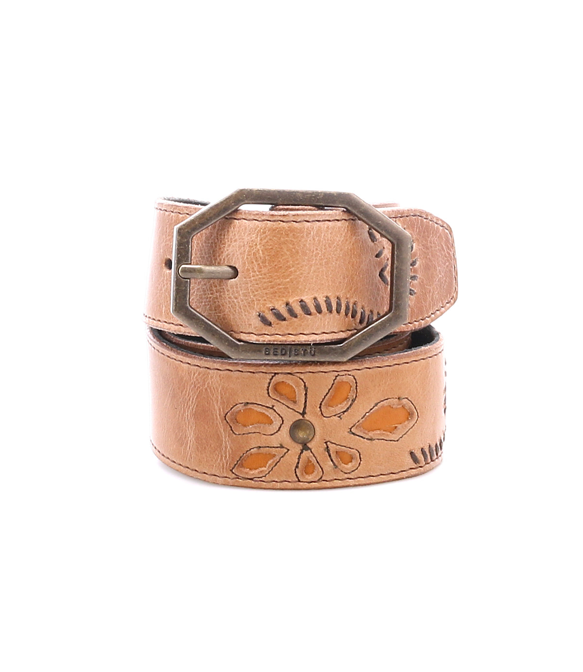 The Upswing II by Bed|Stü is a tan handcrafted leather belt featuring an engraved floral pattern and an octagonal brass buckle, shown rolled up against a white background.
