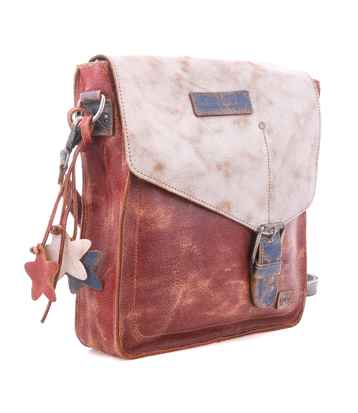 Introducing the Bed|Stü Venice Beach—a crossbody bag crafted from brown and beige full-grain leather, featuring a buckle closure, flap top, adjustable strap, and star-shaped leather charms adorning the side.