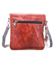 Introducing the Venice Beach by Bed|Stü—a square shoulder bag crafted from brown full-grain leather, featuring a blue adjustable strap and a convenient front zippered pocket. Shown against a white background, this stylish crossbody bag is perfect for everyday use.