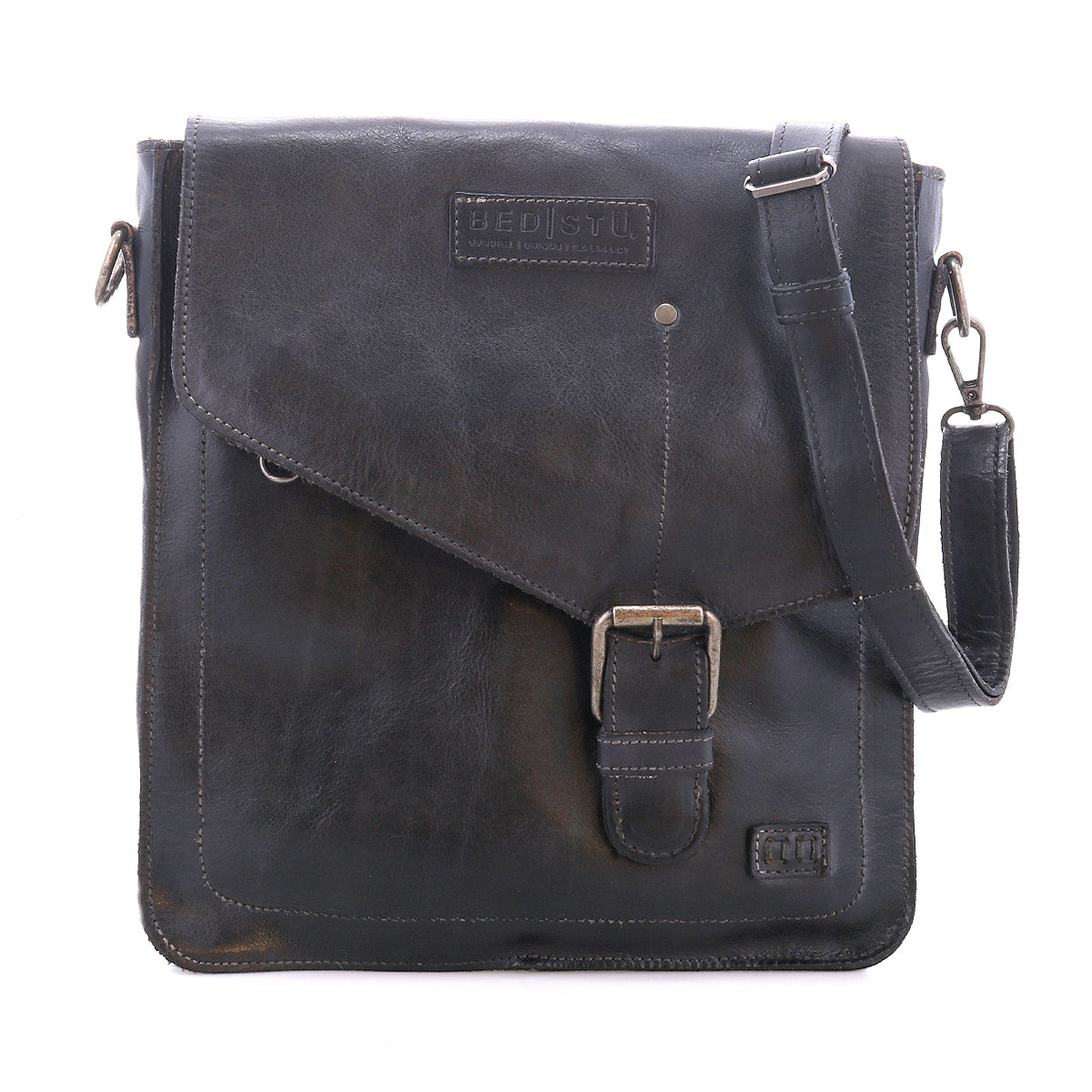 The Bed|Stü Venice Beach messenger bag is crafted from black full-grain leather and features a front buckle, an embossed "BED|STÜ" logo, and an adjustable shoulder strap. Shown against a plain white background, this versatile crossbody bag merges timeless style with practical design.